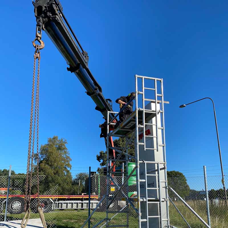 Construction sign installation with crane
